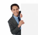 Businessman Peeping Around Board Stock Photo