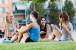 Running Girls Having Fun In The Park With Mobile Phone Stock Photo