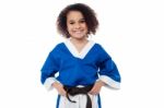 Little Girl Adjusting Her Brown Karate Belt Stock Photo