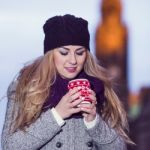 Attractive Young Stylish Blonde Girl Drinks Hot Drink From A Mug Stock Photo