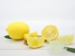 Fresh Lemon Juice In A Small Bowl And Lemon Slice On White Wood Stock Photo