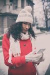 Beautiful Woman In Red Coat And Wool Cap And Gloves With Smartph Stock Photo