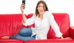 Young Woman Posing While Taking Selfie On Sofa Stock Photo