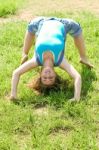 Girl Doing Gymnastic On Grass Stock Photo