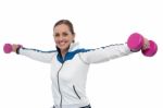 Woman Holding Dumbbells In Her Outstretched Arms Stock Photo