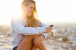 Beautiful Girl Sitting On The Roof And Listening To Music Stock Photo