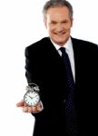 Businessman Showing Alarm Clock Stock Photo