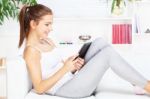 Woman Smiling While Working On Tablet Computer Stock Photo