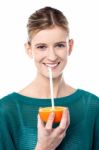 Girl Sipping Orange Juice Through Straw Stock Photo