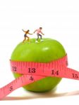 Miniature Woman Skating On Green Apple And Measuring Tape , Thin Stock Photo