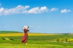 Woman Standing On Green Grass In Green Tea Field Stock Photo