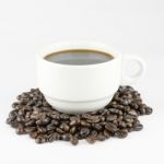 White Cup Of Coffee On Beans Stock Photo