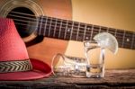 Glass Of Vodka And Classical Guitar With Red Hat Stock Photo