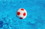 Beach Ball Floating  In Blue Swimming Pool Stock Photo