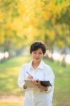 Portrait Of Beautiful Asian Young Woman Staning In Yellow Flower Stock Photo