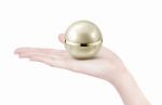 Golden Sphere Cosmetic Jar On Hand Isolated Stock Photo