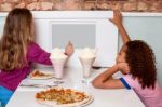 Little Girls Enjoying Pizza In A Restaurant Stock Photo