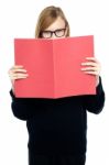 Student With A Red Book Learning Intently Stock Photo