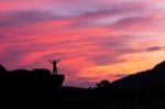 Silhouette Of A Man On The Rock At Sunset Stock Photo