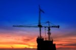 Twilight And Silhouette Construction With Crane On Top Building Stock Photo