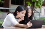 Two Asia Thai High School Student Best Friends Beautiful Girl Using Her Tablet And Funny Stock Photo