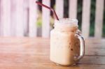 Glass Of Iced Coffee On Wooden Table With Vintage Filter Style Stock Photo