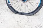 Bicycle Wheel With Flat Tyre On The Concrete Road Stock Photo