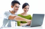 Happy Young Couple Browsing Internet At Home Stock Photo