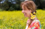 European Woman Wearing Braid With Yellow Flowers Near Coleseed F Stock Photo