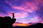 Silhouette Of A Man On The Rock At Sunset Stock Photo