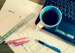 Cup Of Coffee On Laptop With Construction Plans Stock Photo