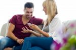 Beautiful Young Couple Using Mobile Phone At Home Stock Photo