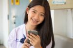 Portrait Of Thai Student Teen Beautiful Girl Using Her Phone And Smile Stock Photo