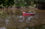 Mother Rowing Her Children Along The River Coquet In Warkworth Stock Photo