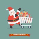 Santa Claus Push A Shopping Cart With Piles Of Presents Stock Photo