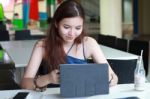 Portrait Of Thai Adult Beautiful Girl Using Her Tablet And Smile In University Stock Photo