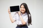 Portrait Of Thai High School Student Uniform Beautiful Girl Using Her Tablet Stock Photo