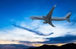 Commercial Airplane Flying At Sunset Stock Photo