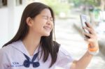 Portrait Of Thai Student Teen Beautiful Girl Using Her Phone And Smile Stock Photo