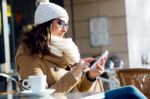 Young Beautiful Woman Using Her Mobile Phone In A Cafe Stock Photo