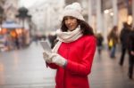 Woman In Red Coat And Wool Cap And Gloves With Smartphone In Han Stock Photo