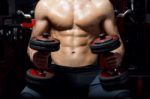 Young Man Doing Heavy Weight Exercise In Gym Stock Photo