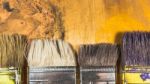 Oil Paint Brushes On Wood Painted Background Stock Photo