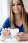 Young Beautiful Woman Using Her Mobile Phone At Home Stock Photo