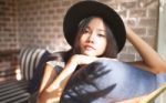 Woman Smiling Near Rustic Brick Wall Stock Photo