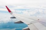 Wing Of An Airplane Flying Above The Clouds Stock Photo