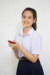 Portrait Of Thai High School Student Uniform Teen Beautiful Girl Using Her Phone And Smile Stock Photo