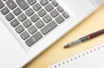 Silver Laptop And Notebook And Pen On Wood Table Stock Photo