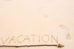 Inscription Of Vacation Written On Wet Yellow Beach Sand With Fo Stock Photo