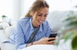 Beautiful Young Woman Using Her Mobile Phone At Home Stock Photo